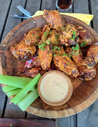 Chicken wings met wat saus ernaast in een houten kom/bord